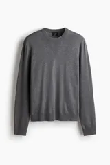 Buzo de punto fino color gris oscuro, de manga larga y cuello redondo, con remates acanalados en cuello, puños y bajo.