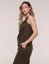 Conjunto de dos piezas de lino verde oscuro, compuesto por un top de un solo hombro con arandela decorativa y un pantalón palazzo de tiro alto con cintura elástica y bolsillos.