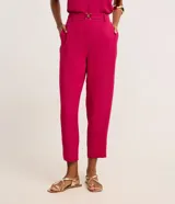 Pantalón zanahoria color fucsia de tiro alto, confeccionado en tejido airflow, con cintura elastizada, trabillas y hebillas metálicas.