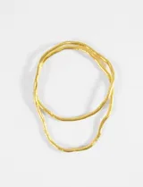Collar largo y flexible de metal dorado, con diseño de cadena tipo serpiente que permite moldearlo y usarlo de múltiples formas.
