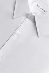 Camisa de corte slim fit confeccionada en tejido de algodón. Presenta cuello italiano, manga larga con puños abotonados y cierre frontal mediante botonadura clásica.