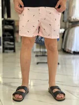 Short de baño negro con pequeño estampado rojo repetido y cordón ajustable en la cintura.