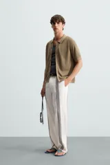 Camisa de punto color marrón, de corte relaxed fit, con cuello solapa, manga corta y acabados en rib. Cierre frontal de botonadura.