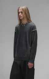 Sweater de cuello redondo con diseño de tejido acanalado vertical en color negro. Presenta detalles de costuras en contraste blanco en los hombros y en el ruedo, con un corte holgado y terminaciones en punto rib.