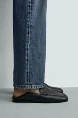 Mocasín de piel negra para hombre, con detalle de antifaz en el empeine, costuras visibles, horma cuadrada y suela ultrafina.