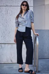 Pantalón de corte sastrero color beige, de tiro alto, con pinzas y largo al tobillo.