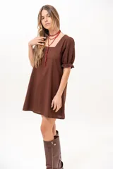 Vestido corto marrón con escote cuadrado, mangas cortas abullonadas con elástico y corte recto.