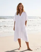 Vestido túnica de lino color blanco, con escote en V, mangas cortas, bolsillos laterales y diseño asimétrico más largo en la parte trasera.