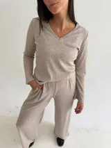 Remera de lanilla con textura acanalada, escote en V y mangas largas con terminación oxford. Presenta un diseño minimalista y cómodo.