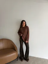 Conjunto compuesto por un buzo de punto acanalado en color beige con cuello redondo y mangas largas holgadas, y un pantalón tipo oxford de tiro alto con estampado animal print de leopardo.