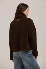 Campera de corderito color marrón, con cuello alto, cierre frontal con botones y terminaciones con ribete al tono.
