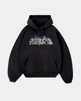 Canguro negro de corte oversize con capucha y bolsillo frontal tipo canguro. Presenta un estampado gráfico central con estilo graffiti que incluye elementos como una figura con sombrero, una casa y detalles en colores.