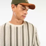 Camiseta de manga corta con cuello redondo, confeccionada en tejido de punto texturizado con rayas verticales en tonos beige claro y verde oliva.