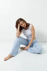 Pantalón de pijama celeste con rayas verticales finas color marrón, con bolsillos laterales y elástico en la cintura.