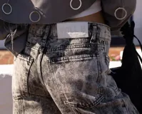 Jean de mujer color gris con efecto acid wash, de corte recto y tiro alto, con costuras frontales y bolsillos laterales.