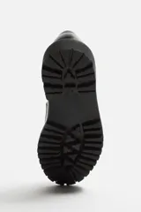 Mocasín de vestir fabricado en piel de alta calidad con detalle de antifaz en el empeine, horma redonda y suela track con ligero volumen.
