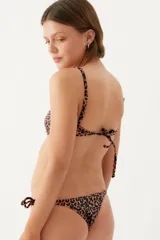 Conjunto de bikini con corpiño triangular de breteles finos y bombacha cavada con tiras laterales, con estampado animal print en tonos marrones.