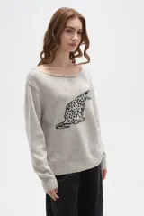 Sweater de tejido de punto color beige con estampado jacquard de leopardo en color negro. Presenta cuello redondo amplio y puños y ruedo acanalados.