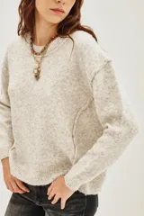 Sweater amarillo de calce relajado, mangas largas, cuello redondo y hombros caídos.