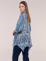 Blusa holgada de poliéster con estampado de arabescos en tonos azules, escote en V con botones frontales, mangas 3/4 y ruedo asimétrico en punta.