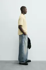 Jeans de hombre, corte balloon fit, tiro medio, confeccionados en denim rígido de algodón. Presentan un efecto lavado con un marcado degradado vertical, cinco bolsillos y cierre frontal con cremallera y botón.