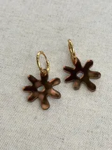 Aros colgantes con forma de engranaje o flor estilizada, con argolla superior para colgar. Diseño en color negro con acabado brillante.