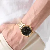 Reloj analógico Guess modelo Chip con caja y brazalete de acero inoxidable en tono dorado. Presenta una esfera negra de 40 mm con acabado sunray, índices dorados y movimiento de cuarzo.