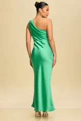 Vestido largo de satén color verde, con diseño asimétrico de un solo hombro y corte al bies que se ajusta a la silueta con una caída fluida.