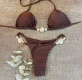 Conjunto de bikini marrón con corpiño triangular con detalle de cuentas en el centro y bombacha cavada con tiritas ajustables y detalle de cuentas en los laterales.