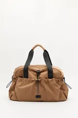 Bolso de nylon en color verde militar, con diseño deportivo, asas de mano resistentes, cierre superior y bolsillos laterales con frunce ajustable mediante cordón elástico.