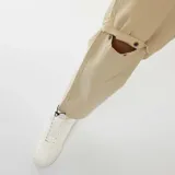 Pantalón de gabardina color beige, con diseño convertible 2 en 1 que permite desmontar la parte inferior para transformarlo en short. Presenta corte recto, bolsillos laterales y ajuste en los tobillos con cordón elástico.