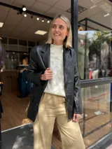 Blazer de cuero sintético en color marrón oscuro, con cierre frontal de dos botones y solapas clásicas.