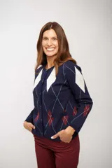 Saco tipo cardigan de punto con diseño de rombos en colores azul, blanco y bordó. Presenta cuello redondo, cierre frontal con botones y bolsillos delanteros.