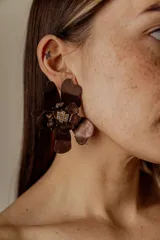 Par de aros con forma de flor roja y centro con strass.