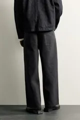 Jeans relaxed fit de corte recto y tiro medio, color negro, confeccionados en denim de algodón rígido con diseño de cinco bolsillos y cierre frontal de cremallera y botón.