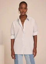 Camisa celeste de corte recto, con cuello clásico, mangas largas con puños abotonados y cierre frontal con botones.