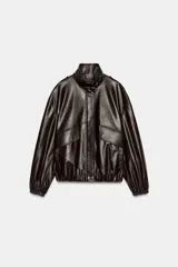 Cazadora de piel 100% de color marrón oscuro, con cuello subido, manga larga con puño elástico y bolsillos frontales con solapa. Presenta cierre frontal con cremallera y botones a presión.
