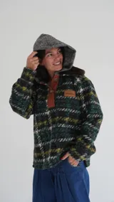 Buzo canguro oversize de paño de lana gris con capucha estampada y cuello de corderito blanco. Cuenta con aberturas laterales en el ruedo y detalles de cuero sintético marrón en el cierre frontal y etiqueta.