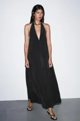 Vestido midi de tejido fluido color negro, con cuello halter anudado en la nuca y escote en pico.