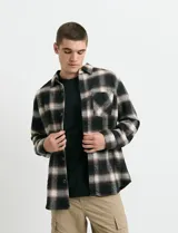Sobrecamisa de manga larga con diseño a cuadros, cuello camisero y bolsillo frontal. Confeccionada en tejido de poliéster y algodón, sin forro.