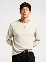 Camiseta de manga larga estilo Henley, confeccionada en tejido de algodón con textura tipo waffle. Presenta cuello redondo con tapeta de tres botones y ajuste regular.