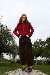Cardigan reversible de punto con diseño de rombos pequeños, cuello redondo y cierre frontal con botones. Presenta un patrón bicolor en tonos bordó y rojo.