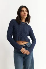 Sweater azul marino de punto trenzado, corte crop y mangas largas.