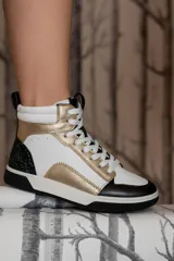 Zapatillas botitas de cuero sintético color blanco con detalles en dorado, negro y glitter negro en el talón.