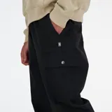 Pantalón cargo negro de corte holgado, con cintura elástica, bolsillos laterales tipo cargo y puños elásticos en los tobillos.