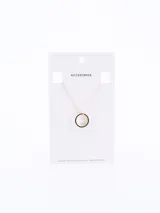 Cadena fina de eslabones con dije circular minimalista en tono dorado.