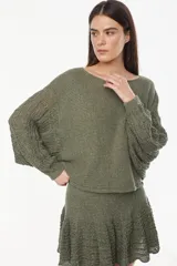 Sweater cropped de punto calado, color celeste melange, con mangas anchas de diseño holgado y cuello redondo.