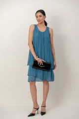 Vestido corto de seda color azul, sin mangas, con escote redondo y diseño en capas con volados.