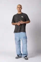 Remera negra con efecto acid wash, corte oversize y pequeño estampado tipográfico en el pecho con la frase 'A daily meeting point'.