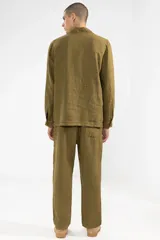 Pantalón de lino color verde oliva, de corte recto y fit relajado. Tiene cintura elástica con cordón de algodón, bolsillos laterales y bolsillo trasero.